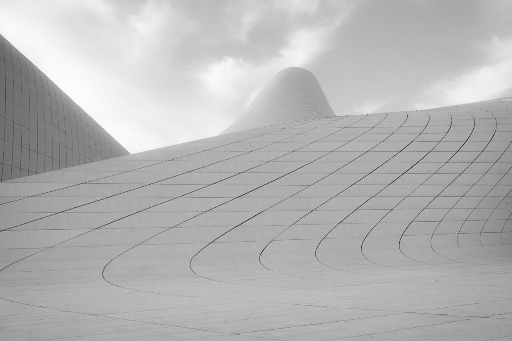 Sleek curves of Heydar Aliyev Centers exterior showcasing modern architectural design in black and white.